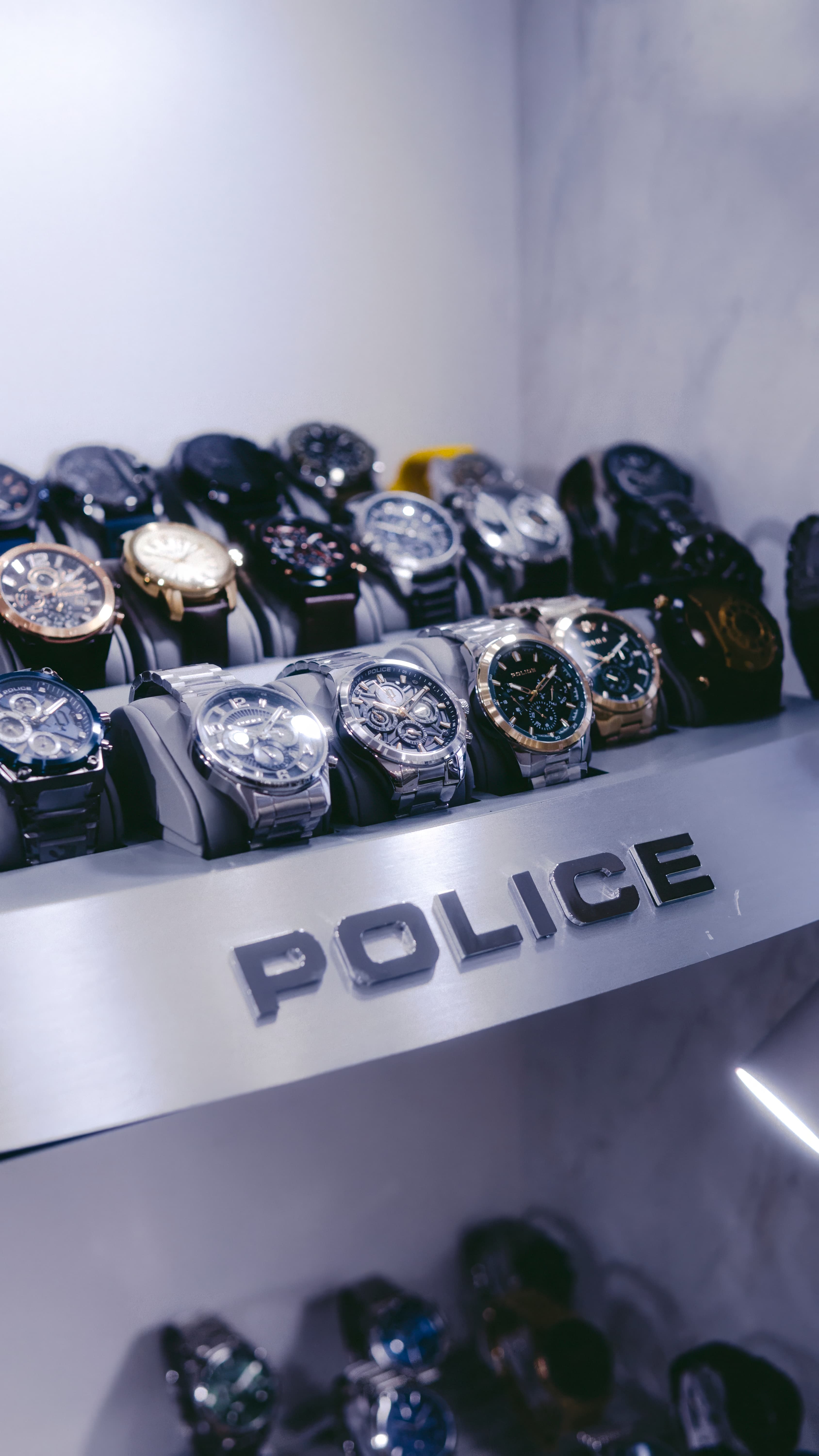 Police watches arranged in a branded Pulito display